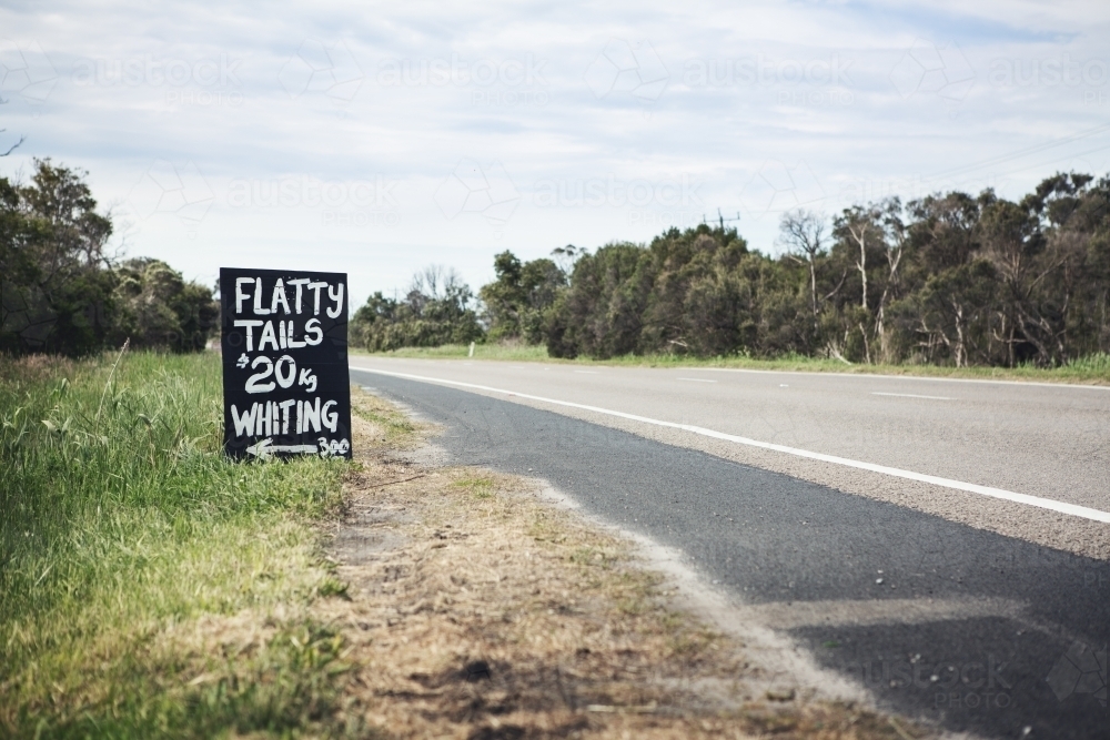 Black and white roadside sign advertising flathead tails horizontal - Australian Stock Image