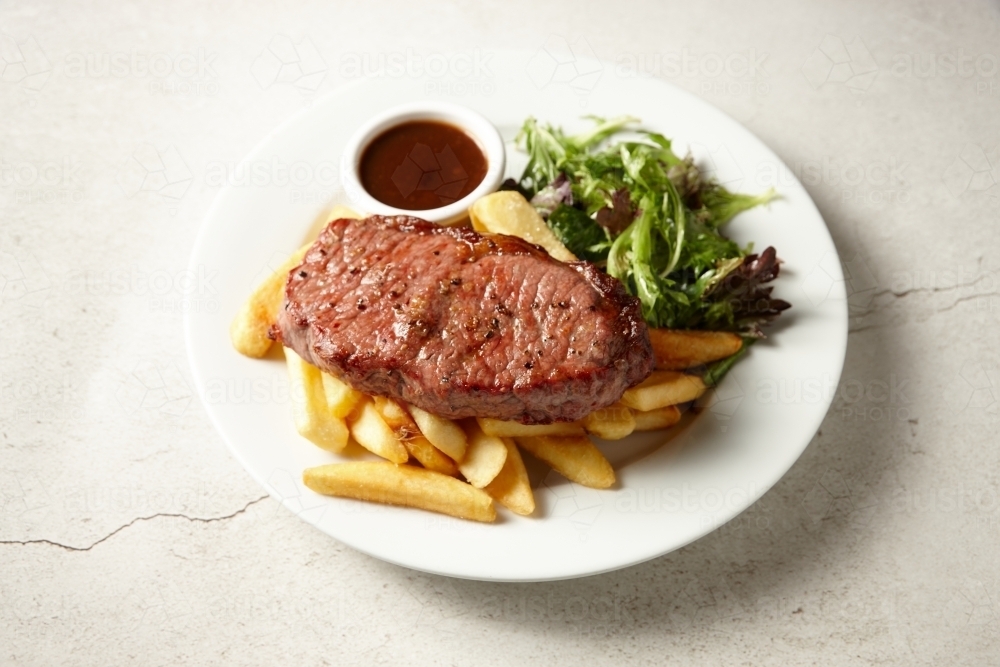 Black angus sirloin steak with fries and salad - Australian Stock Image