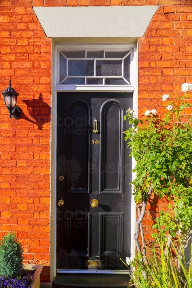 Black front door entrance to number 50 in urban streetscape - Australian Stock Image