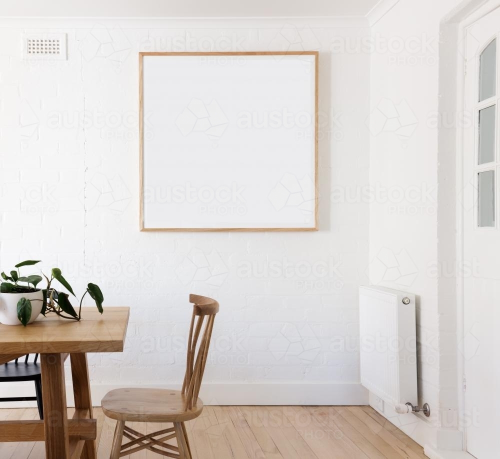 Blank framed print on white wall in beautiful danish styled interior dining room - Australian Stock Image