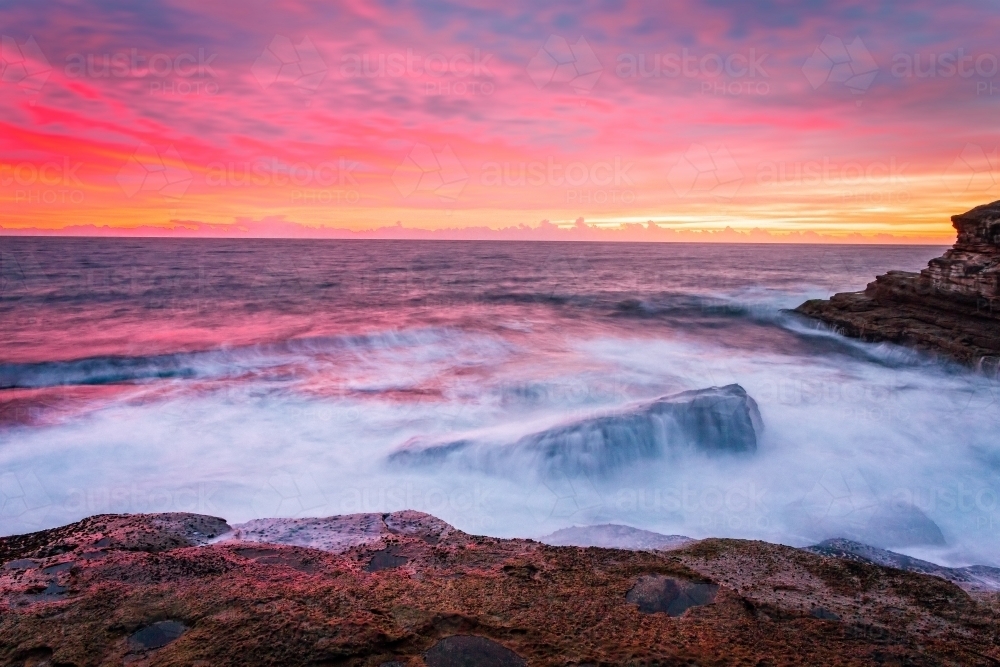 Blazing red pink orange and yellow sunrise skies over the east Sydney coastline - Australian Stock Image