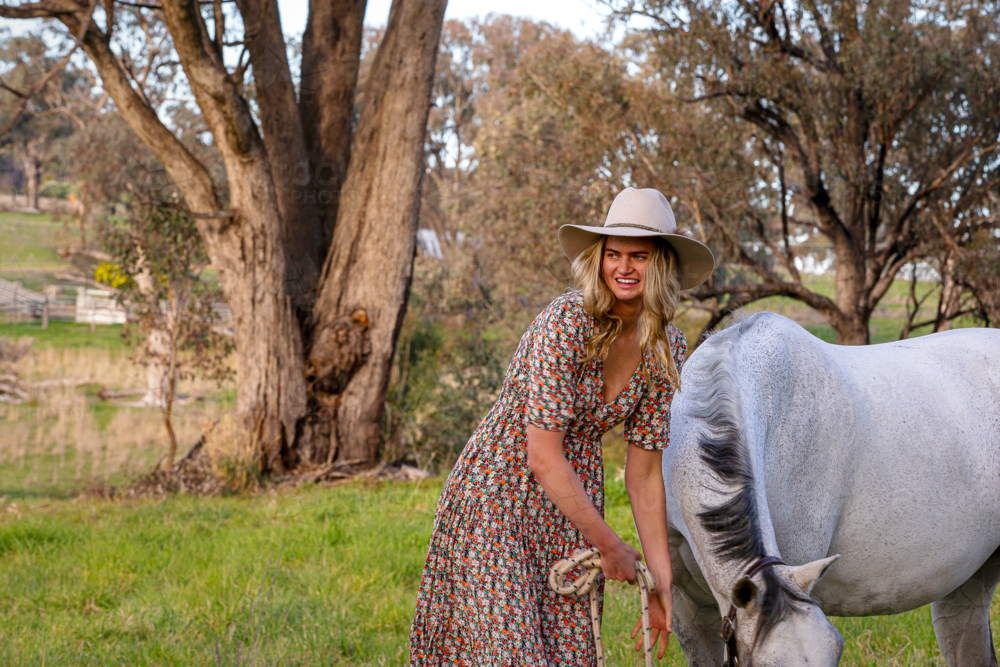 Blond cowgirl with white dressage horse - Australian Stock Image