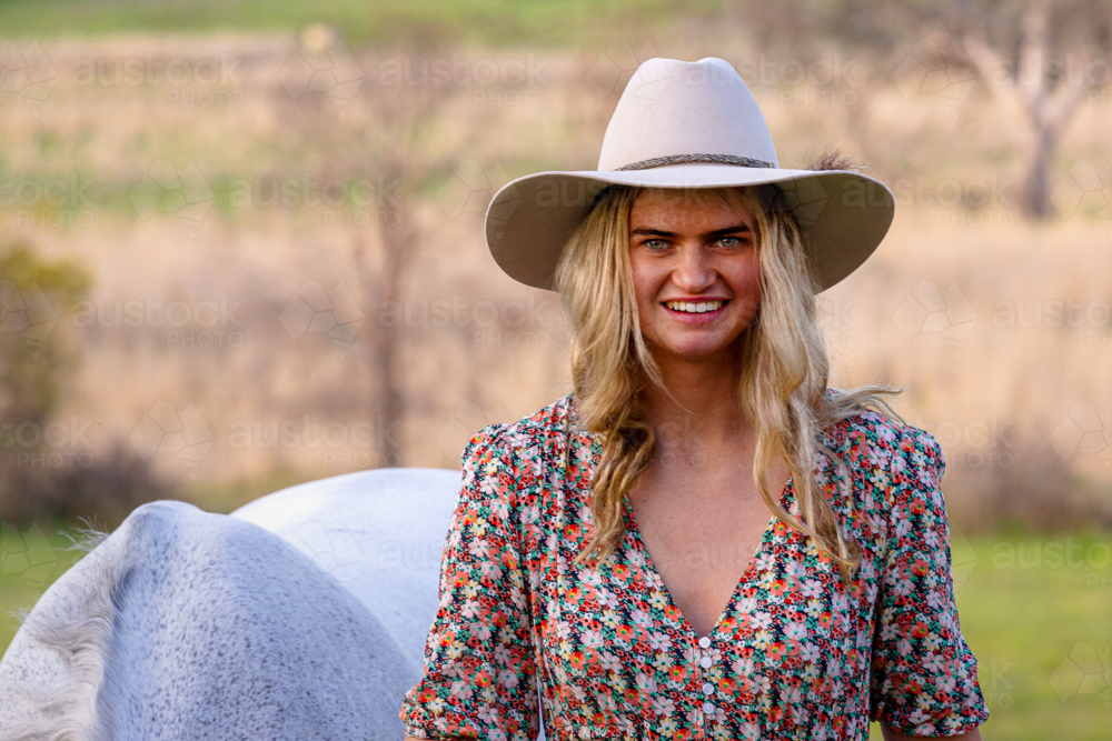 Blond cowgirl with white dressage horse - Australian Stock Image