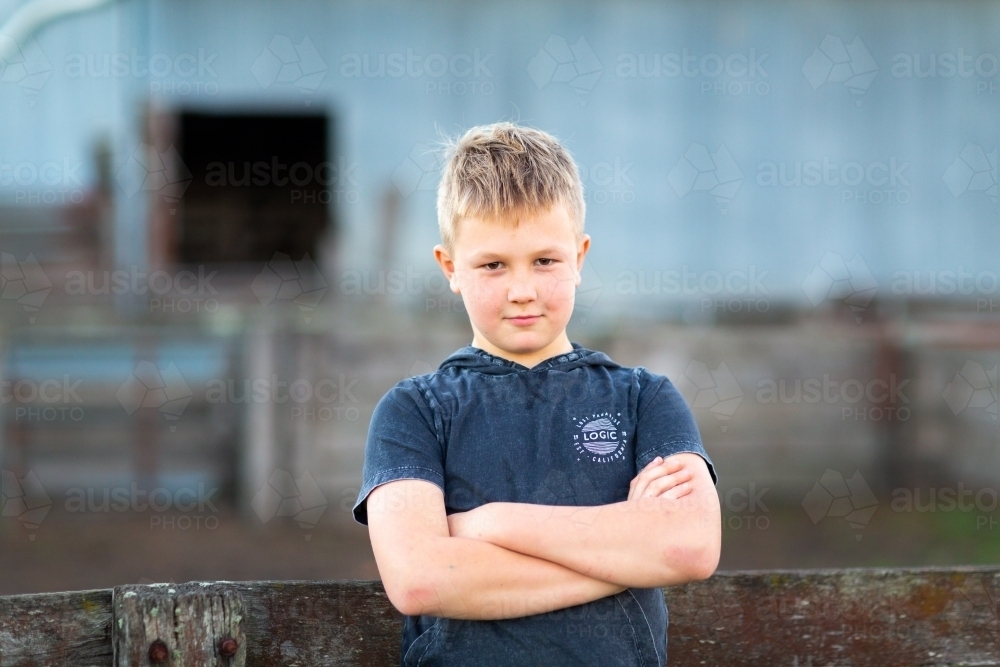 Blonde boy outdoors with arms crossed - Australian Stock Image