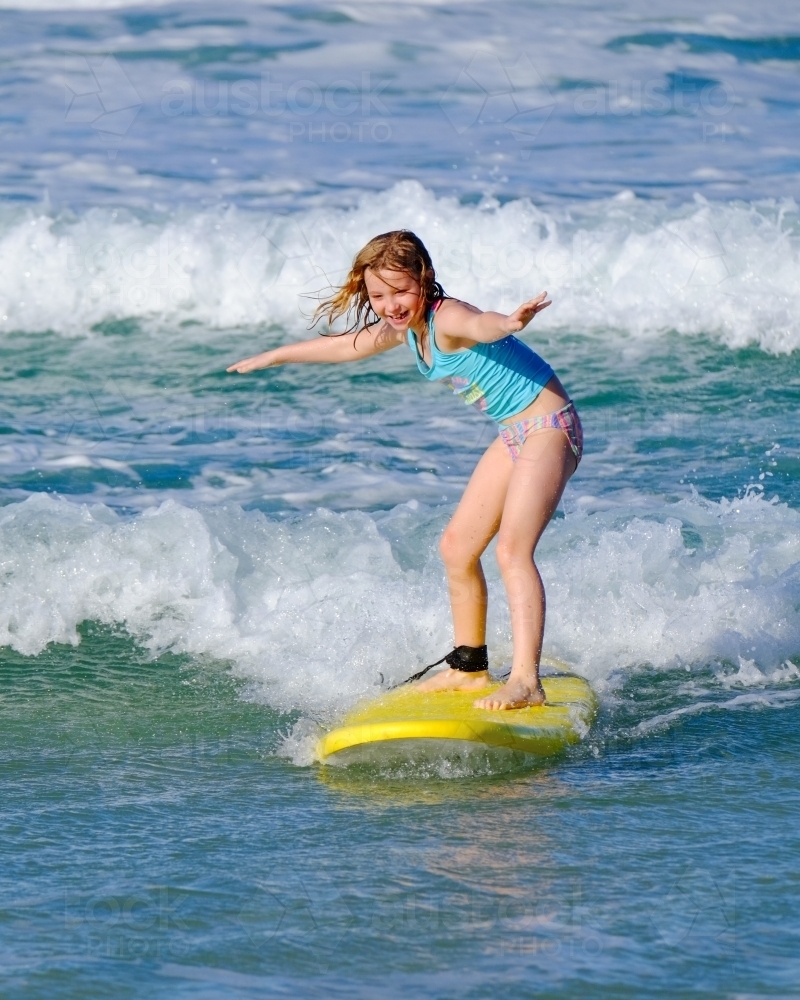 Blonde girl surfing off South Stradbroke Island on the Gold Coast - Australian Stock Image