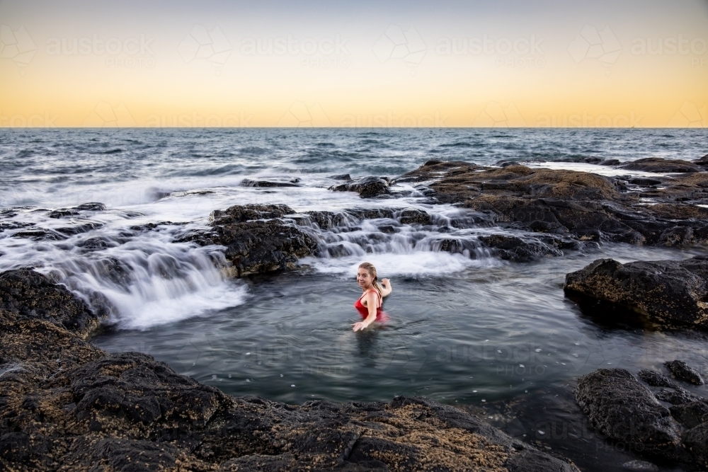 Blonde woman bathing in ocean rock pool - Australian Stock Image