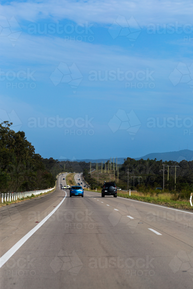 Blue car on the road driving down Australian Highway in NSW australia - Australian Stock Image