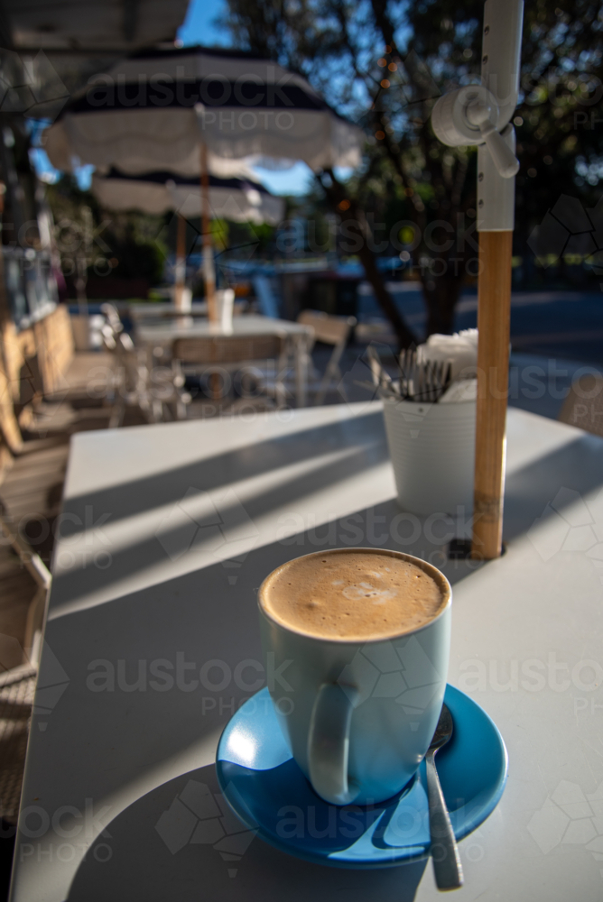 Blue coffee cup on a table early in the morning - Australian Stock Image