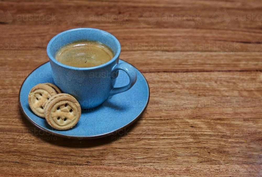 Blue cup with black coffee and two biscuits - Australian Stock Image