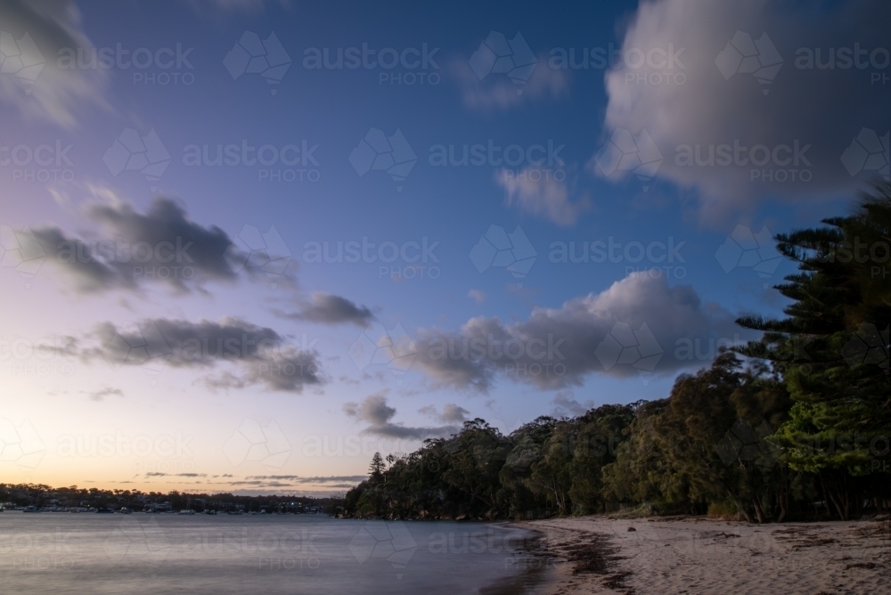 Blue hour photo at an urban beach with clouds in the sky - Australian Stock Image