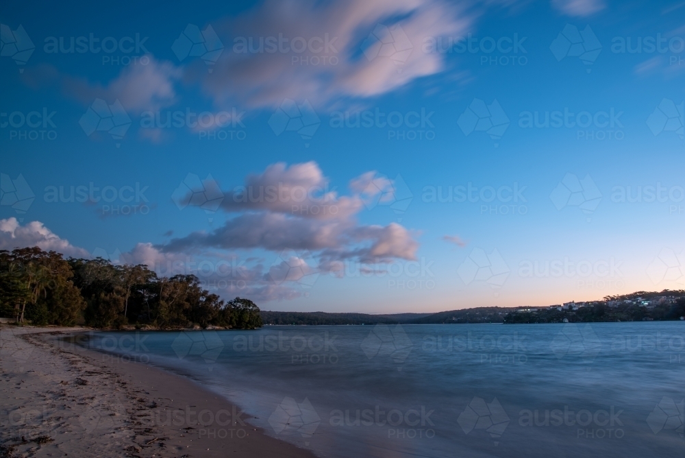 Blue hour photo of urban beach with clouds in the sky - Australian Stock Image