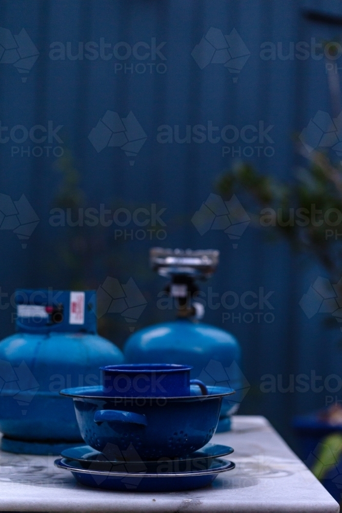 Blue objects on table in front of blue fence - Australian Stock Image