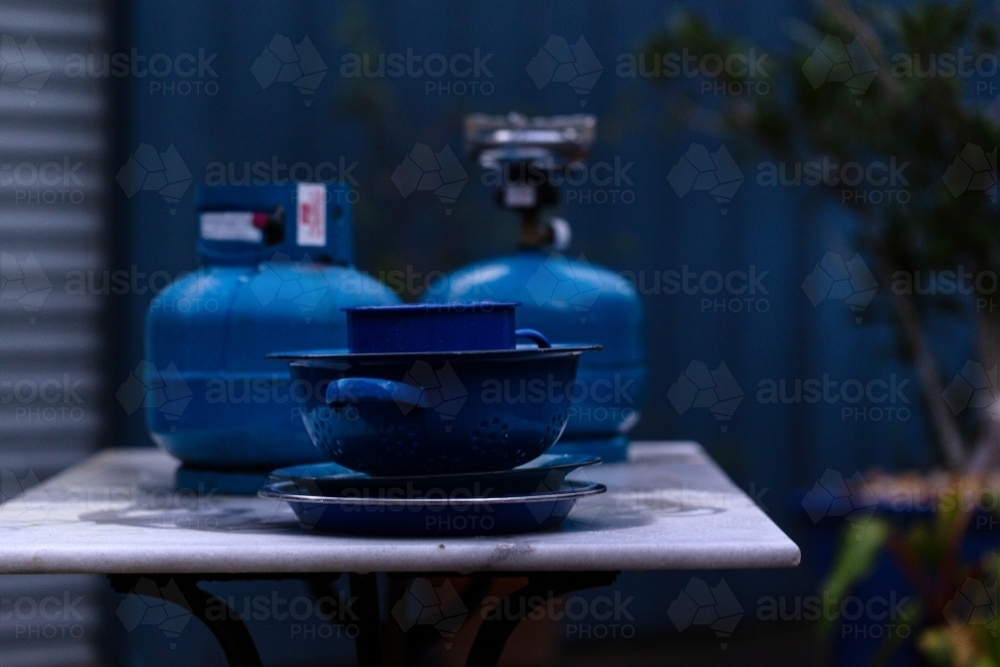 Blue objects on table in front of blue fence - Australian Stock Image