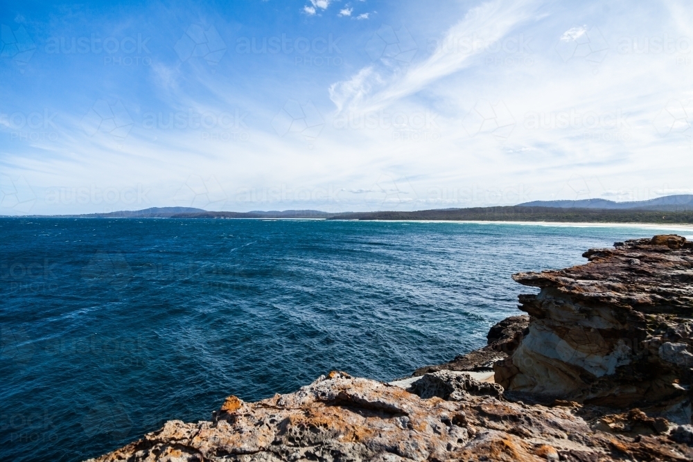 Blue ocean water and rocks of an island of the coast - Australian Stock Image