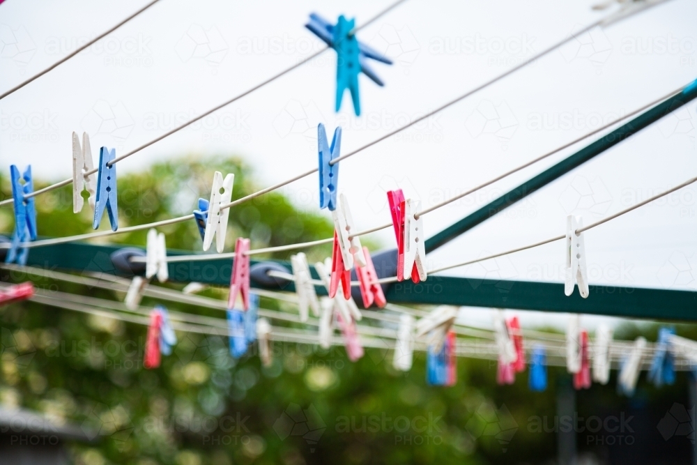 Blue pink and white plastic clothes pegs on a washing line - Australian Stock Image