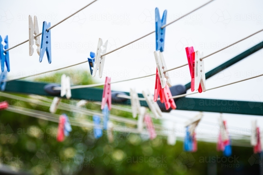 Blue pink and white plastic clothes pegs on a washing line - Australian Stock Image