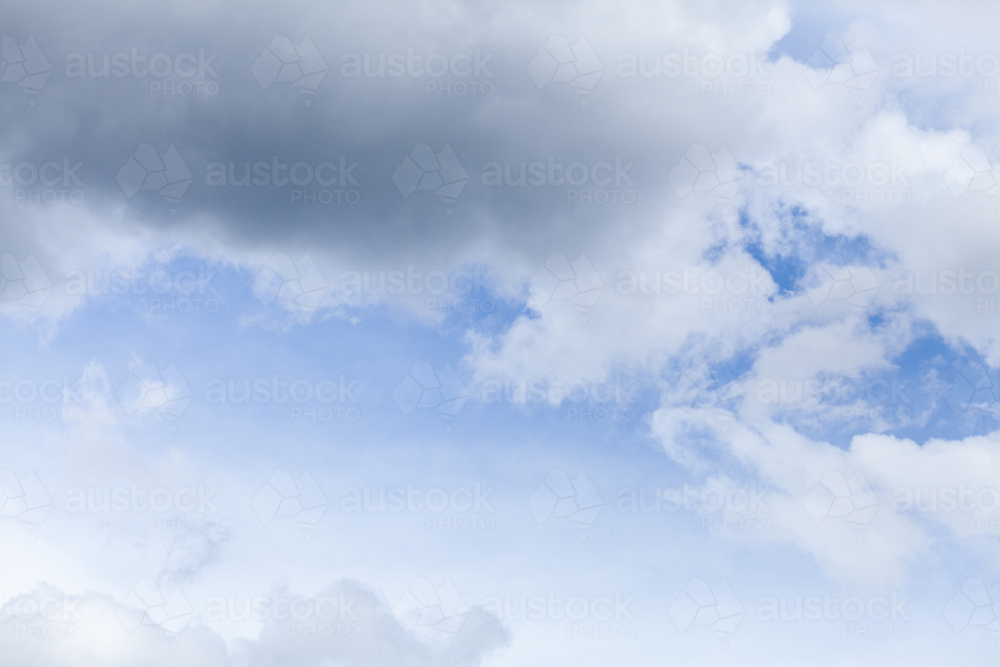Blue spot of sky appearing through cloudy grey sky after rain - Australian Stock Image