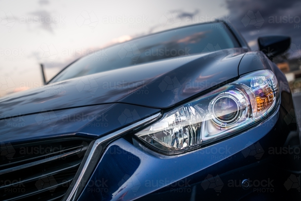 Blue station wagon on suburban street with luxury homes - Australian Stock Image