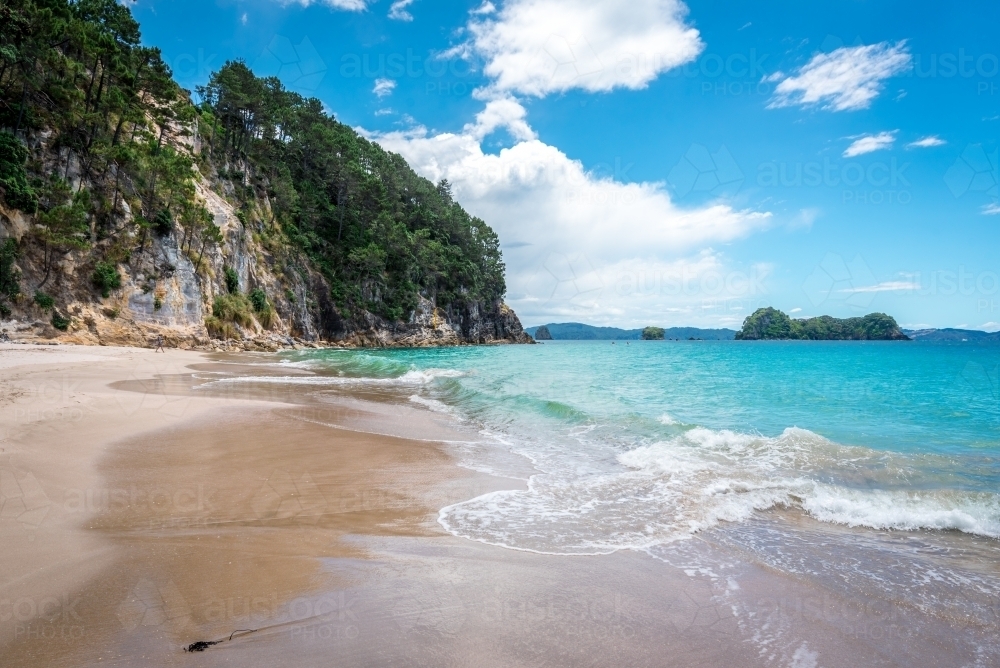 Blue water beach with high sand stone cliffs - Australian Stock Image