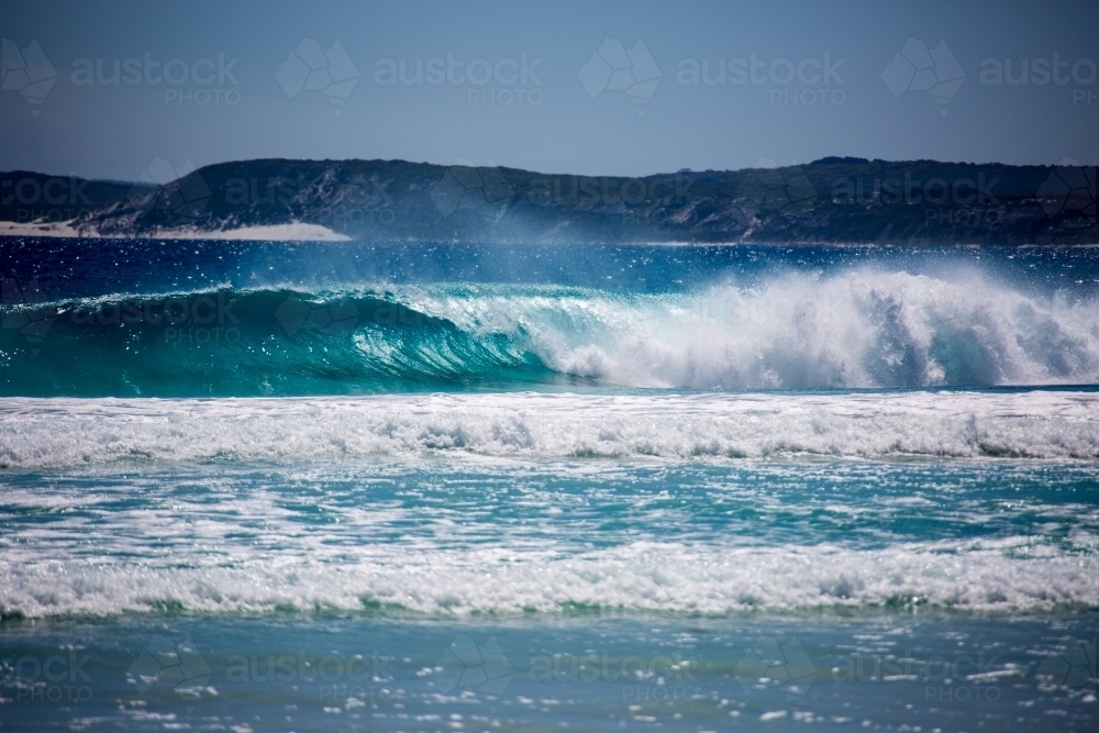 Blue water with waves crashing at beach - Australian Stock Image