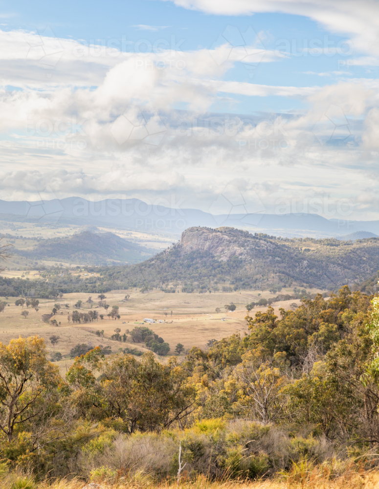 Image of Bluff Rock, a granite outcrop overlooking brown country fields ...
