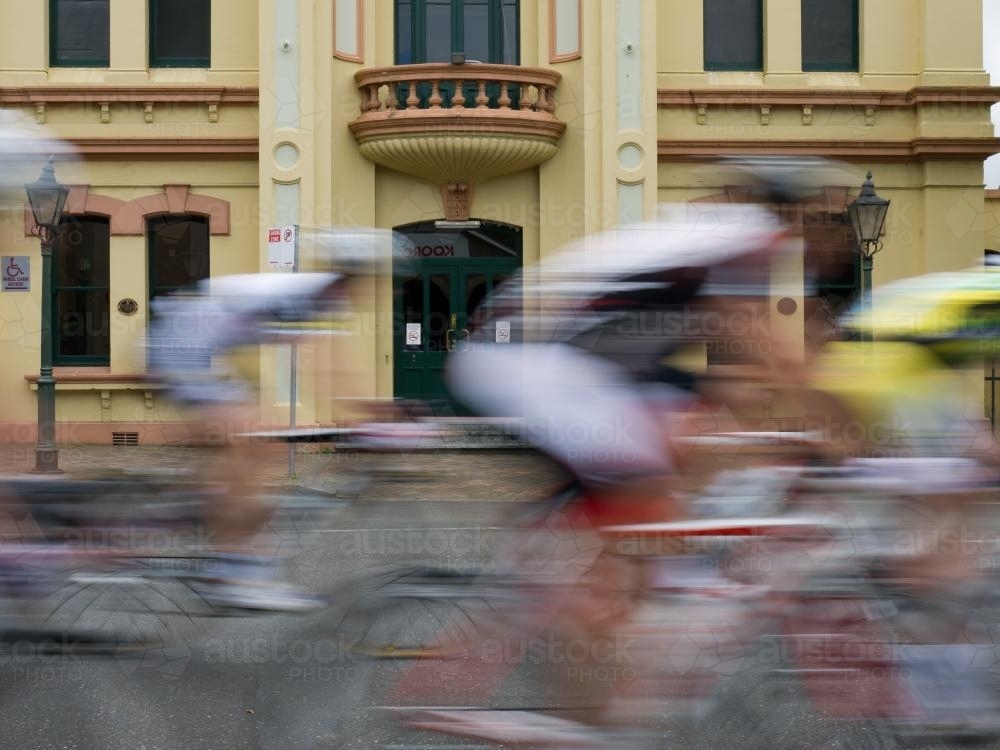 Blurred group of cyclists passing the Armidale Town Hall - Australian Stock Image