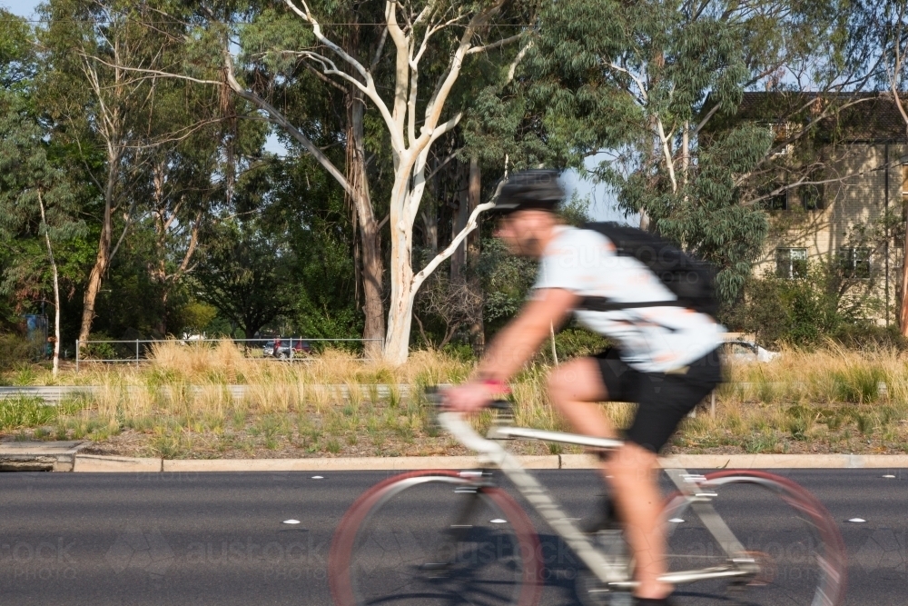 Blurred image of a cyclist commuting to work - Australian Stock Image