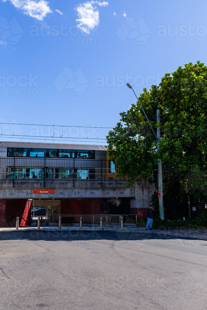 blurred person and train in city passing Narwee train station platform - Australian Stock Image