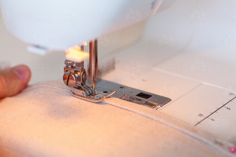 Image of Blurred sewing machine needle going into canvas fabric