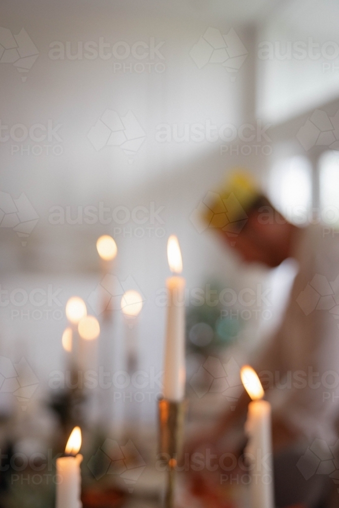 blurry candles with man out of focus in the background - Australian Stock Image