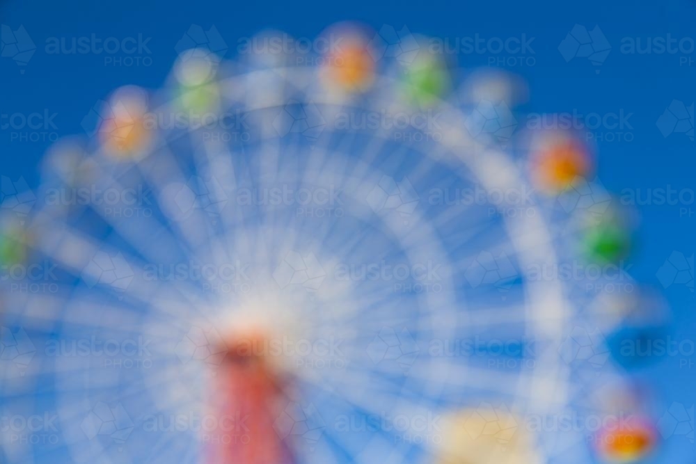 Blurry image of a colourful ferris wheel - Australian Stock Image
