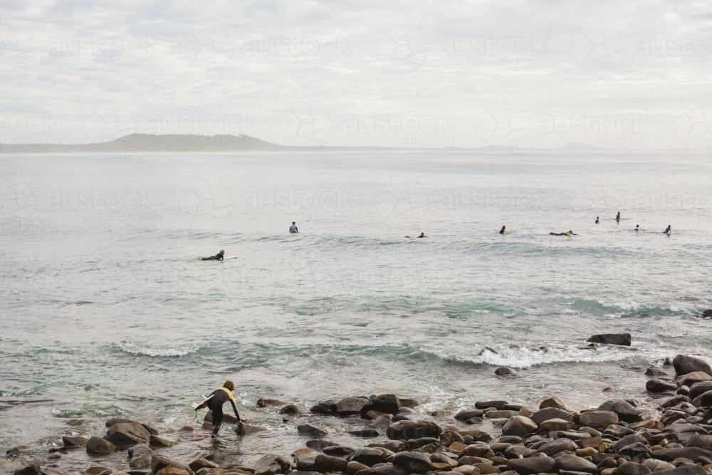 Board Surfers shown from rock outcrop - Australian Stock Image