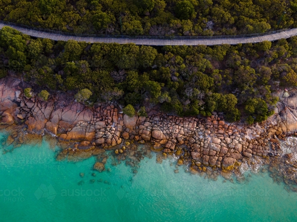 Boardwalk along coastline with clear turquoise water - Australian Stock Image