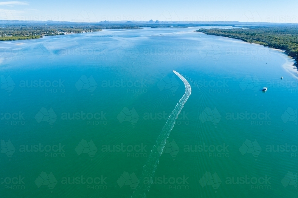 Boat and wake on Pumicestone Passage. - Australian Stock Image