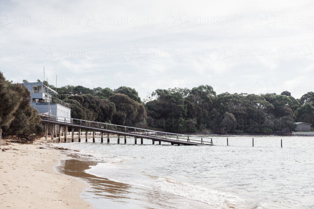 Boat club with boat launch on beach with bush in background - Australian Stock Image