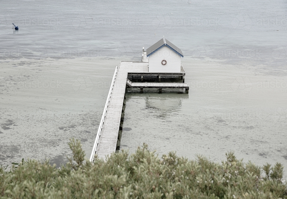 Boat shed and pier on the water at low tide - Australian Stock Image