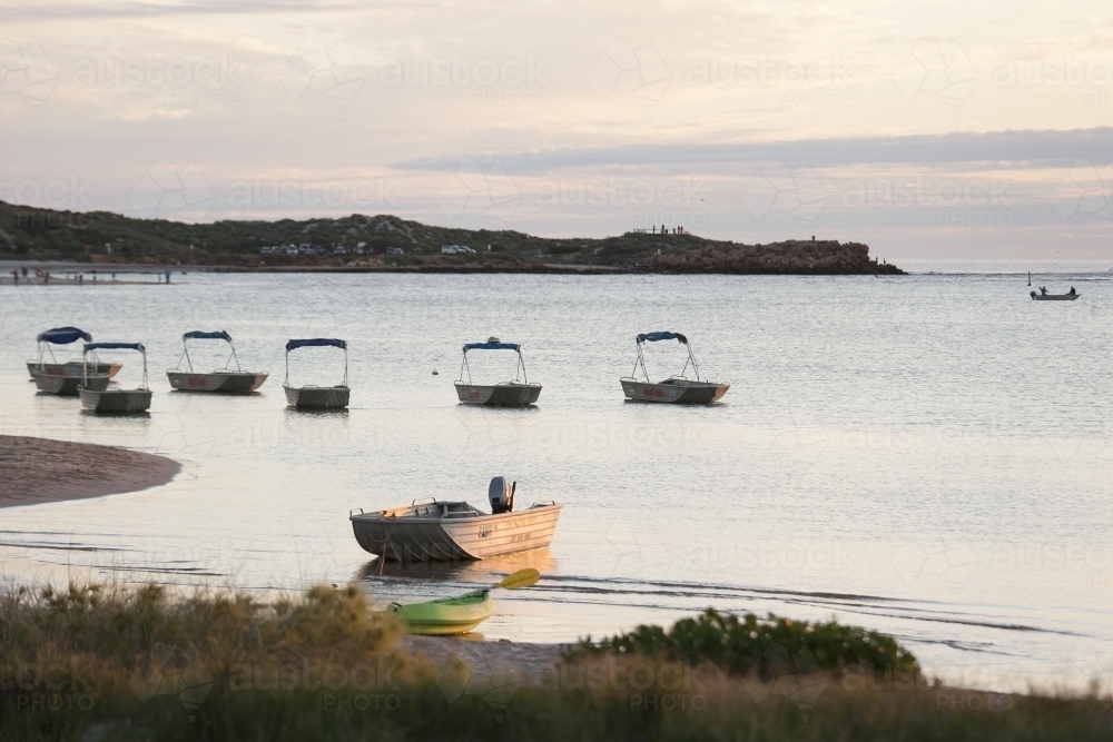Boats and kayak in bay at sunset - Australian Stock Image