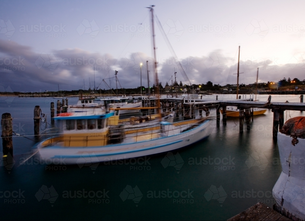 Boats rocking back and forth while docked at jetty - Australian Stock Image