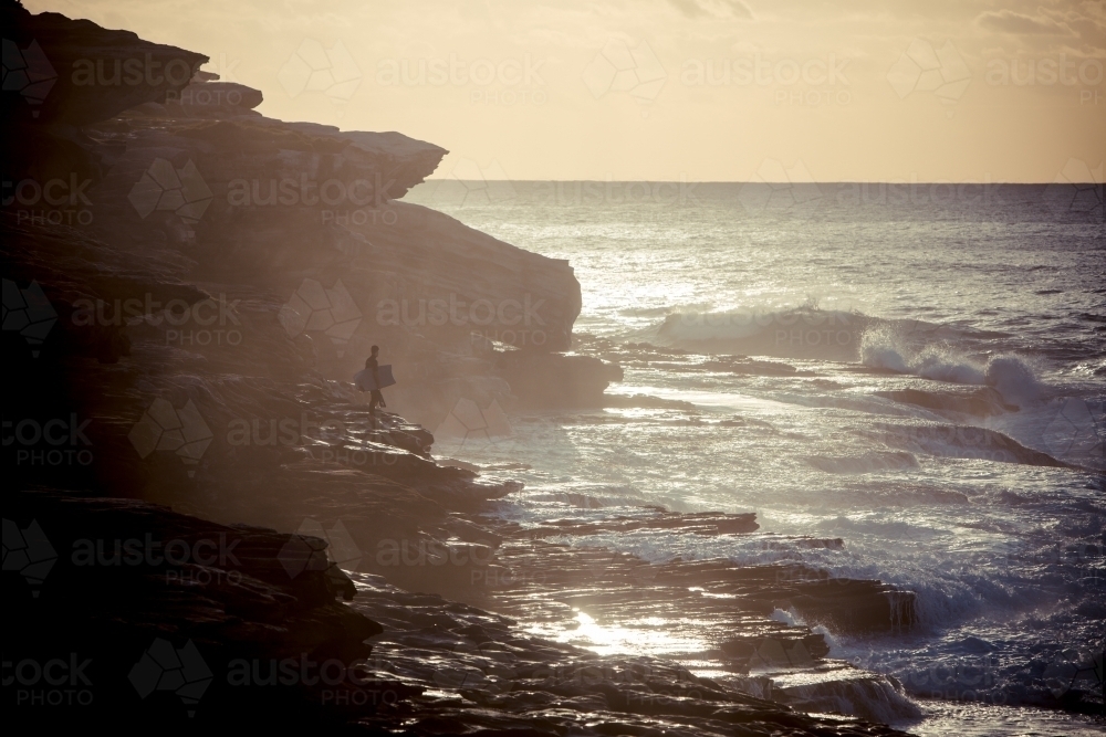 Bodyboarder on the rocks waiting for his wave - Australian Stock Image