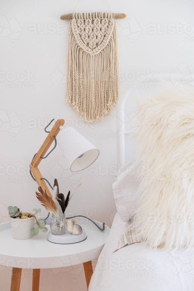 Bohemian style bed with side table and macrame - Australian Stock Image