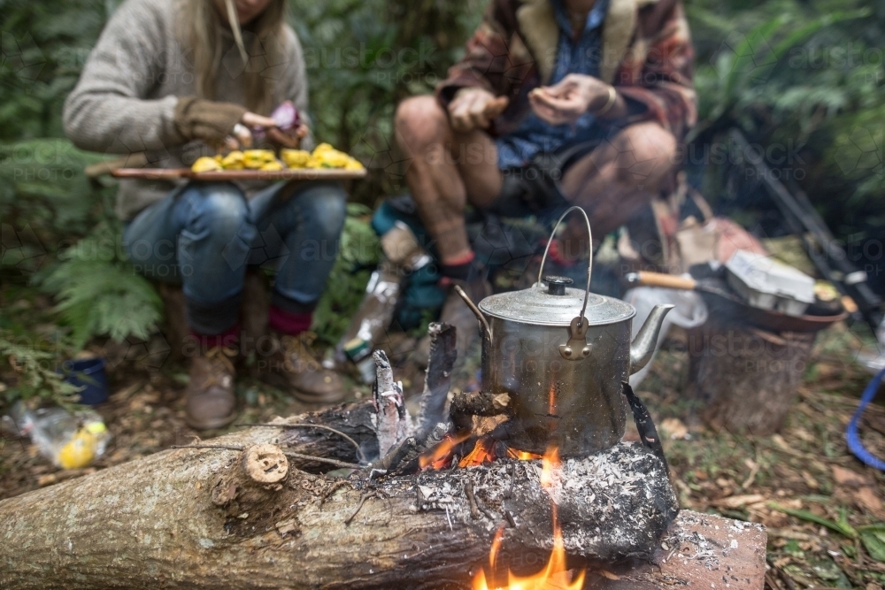 Boiling tea and breakfast over a camp fire - Australian Stock Image