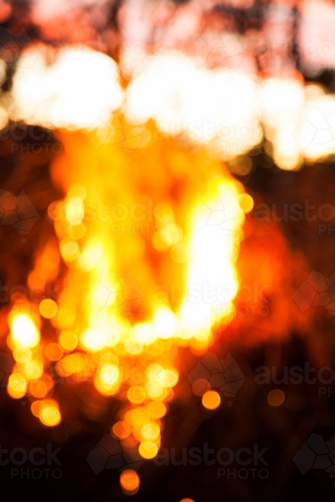 Bokeh light of a bonfire at sunset in the bush - Australian Stock Image