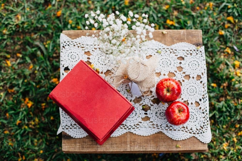 Book, apples and decorations on a table - Australian Stock Image