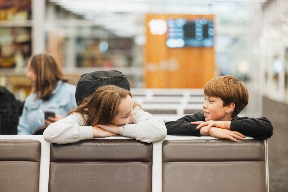 Bored kids waiting for flight in airport departure lounge - Australian Stock Image