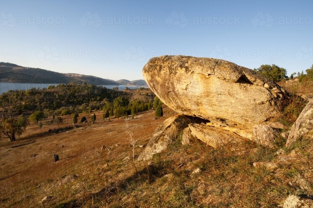 Boulder in paddock overlooking Wyangala Dam - Australian Stock Image