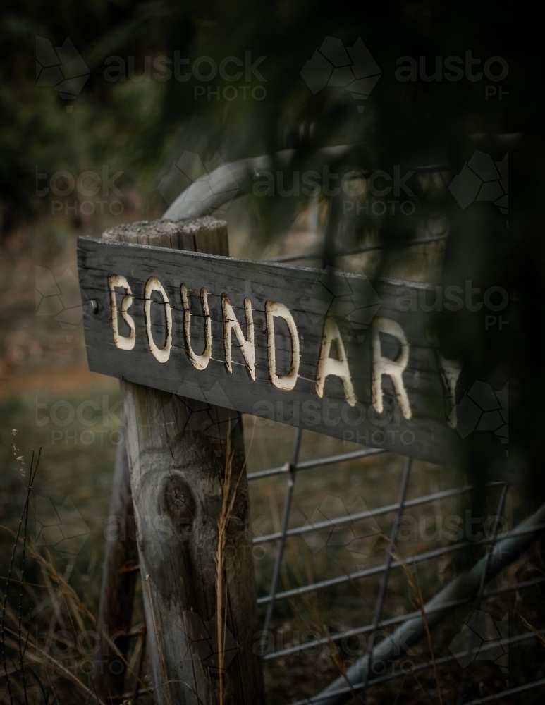 BOUNDARY -  Worn Out Wooden Sign on the edge of a Moody Forest - Australian Stock Image
