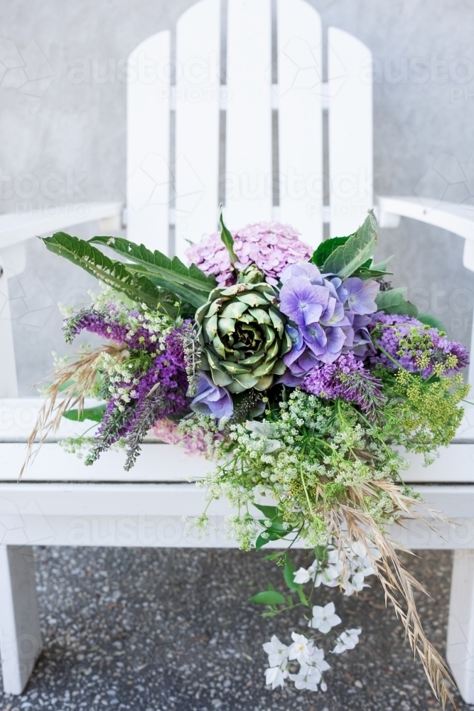 Image of Bouquet of flowers on a garden seat Austockphoto