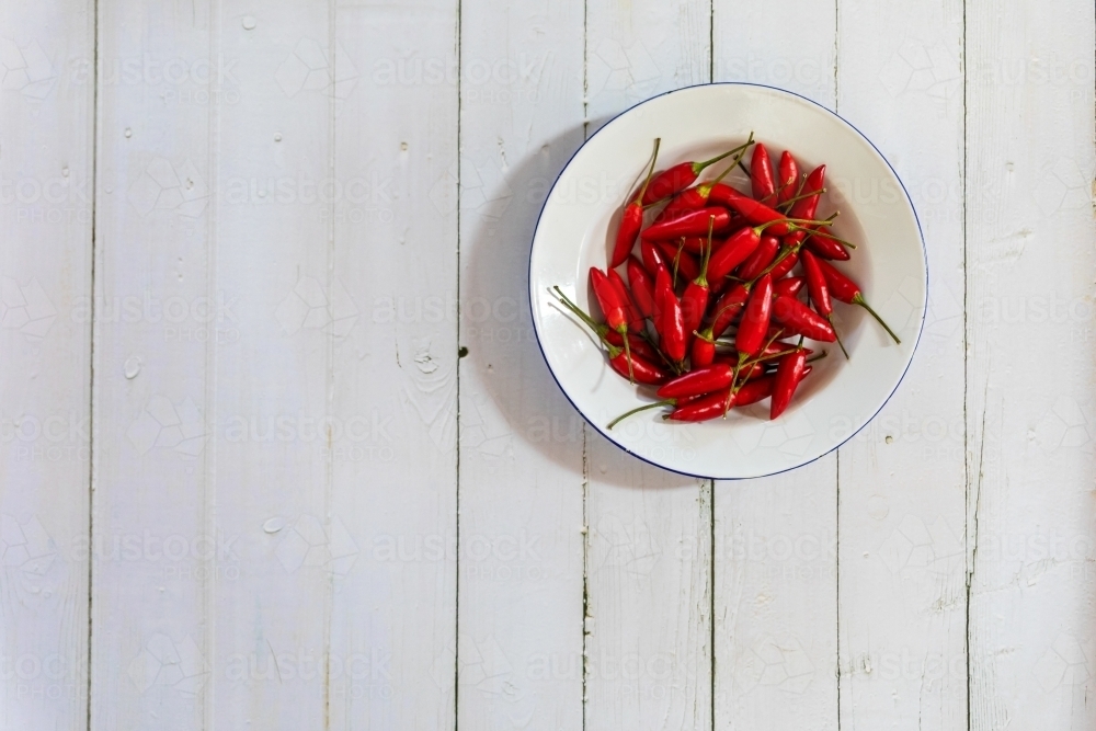bowl of chillies on white background - Australian Stock Image