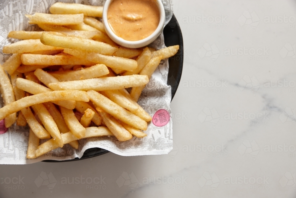 Bowl of hot chips with dipping sauce - Australian Stock Image