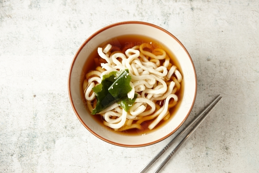 Image of Bowl of Japanese noodles with seaweed and metal chopsticks on Image of Bowl of Japanese noodles with seaweed and metal chopsticks on